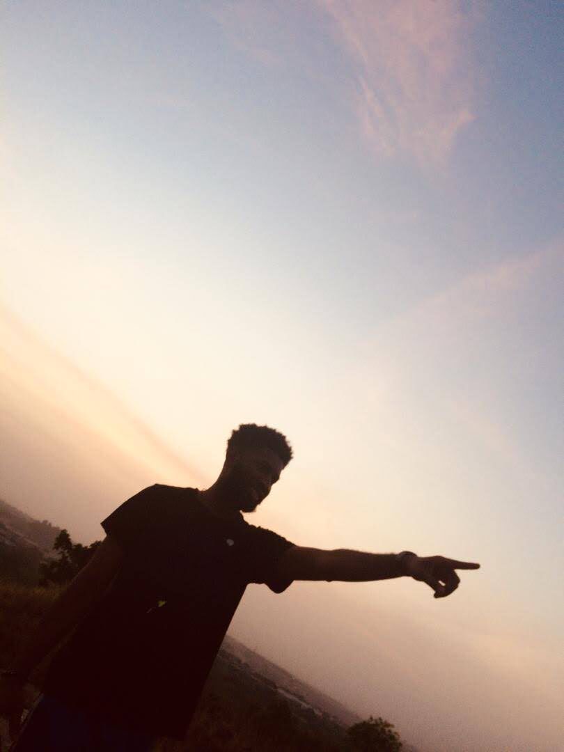 Jerry in silhouette pointing ahead at sunset